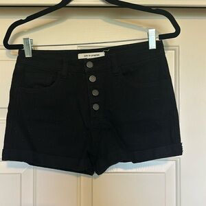 Black denim shorts with button detail.